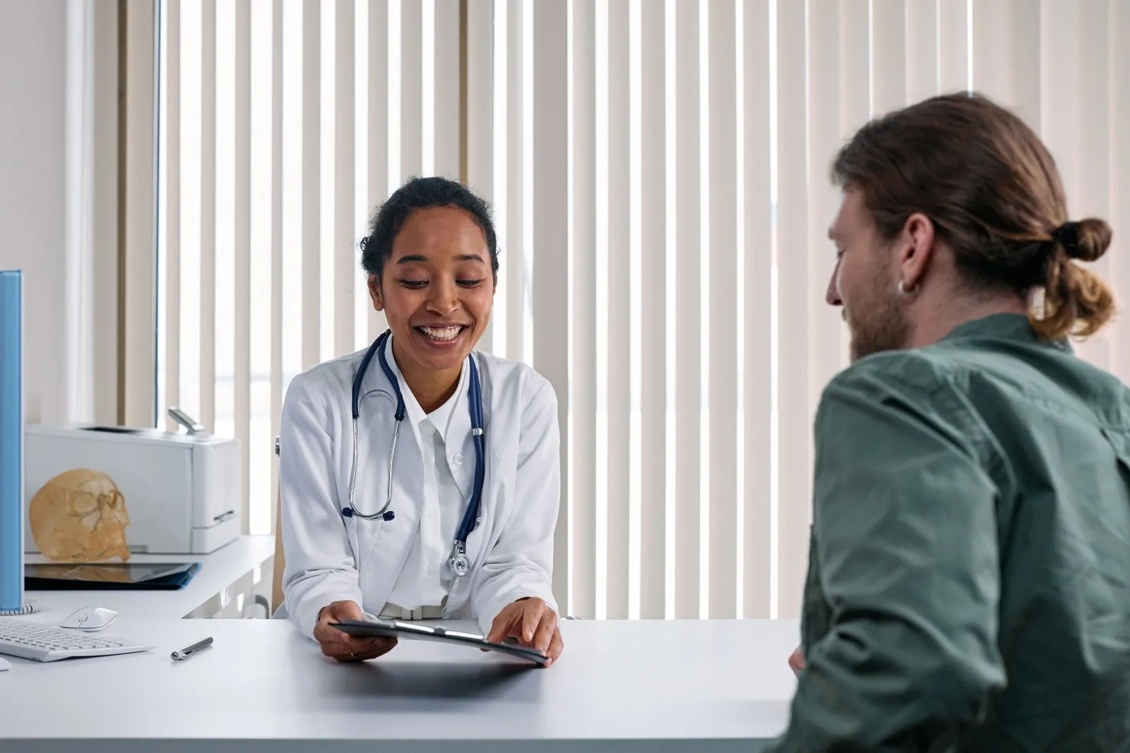 A doctor talking with a patient across a desk